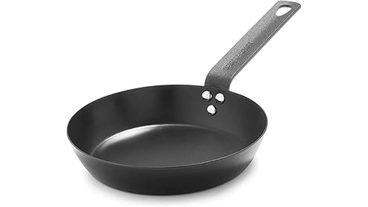 The image shows a collection of high-quality carbon steel pans, likely Top Rated 31 Cookware.